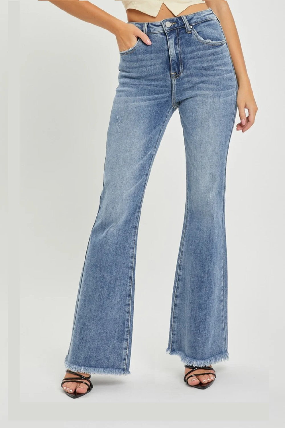 A classic pair of retro-inspired flare leg jeans in medium wash with a raw hem