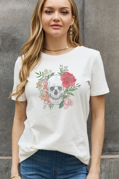 A woman wearing a white classic fit round neck graphic tee with a floral and skull motif.