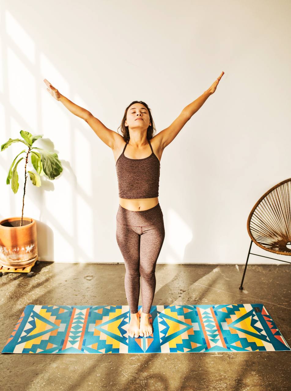 A woman practicing yoga on a Pendleton print yoga mat