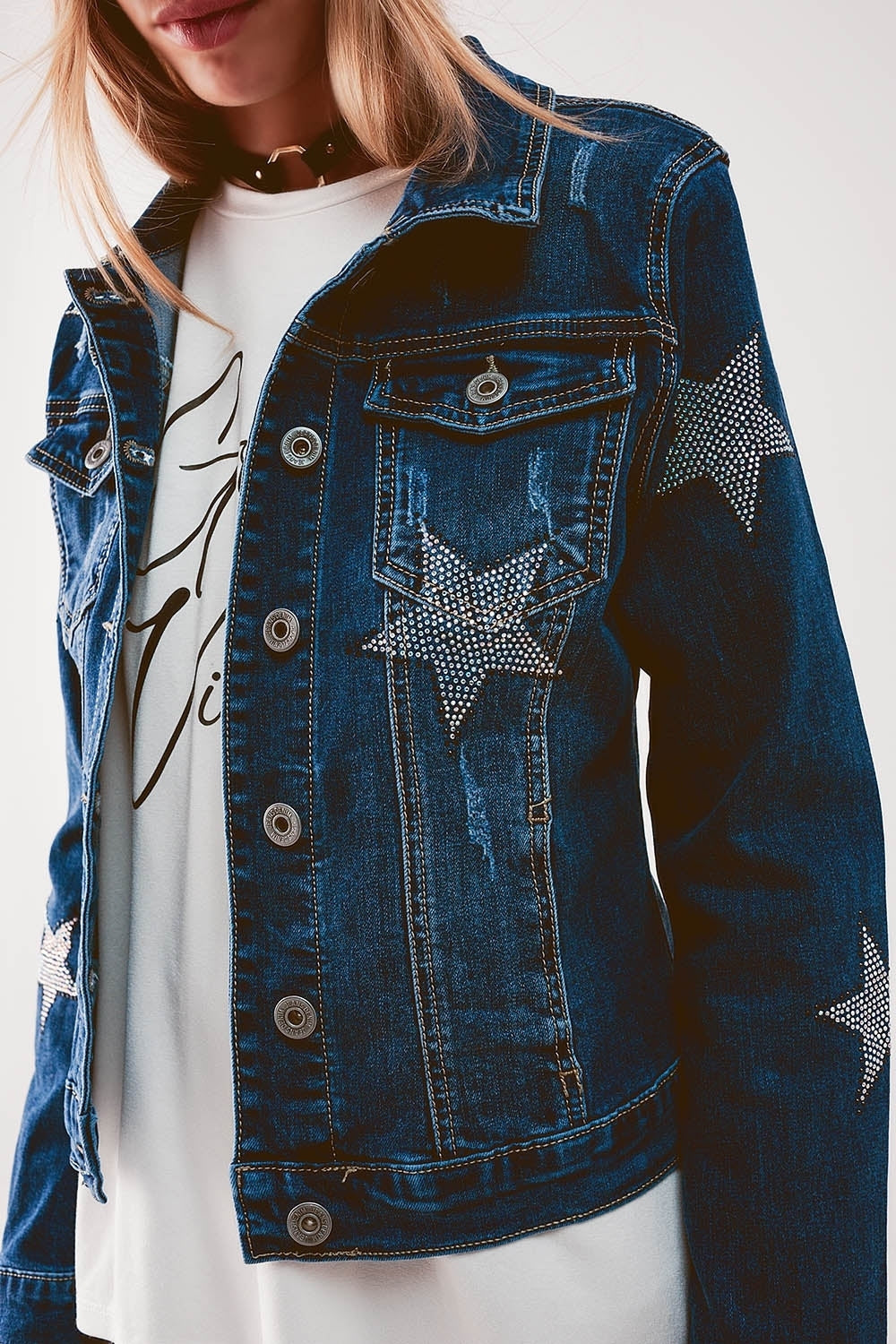 A woman wearing a classic denim jacket decorated with star embellishments