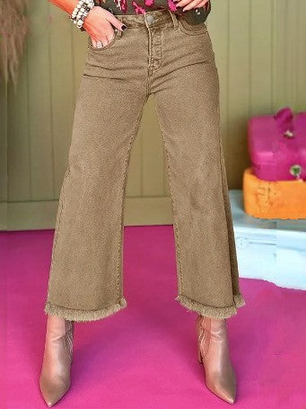 A close shot of a pair of khaki wide leg ankle jeans with a raw hem.