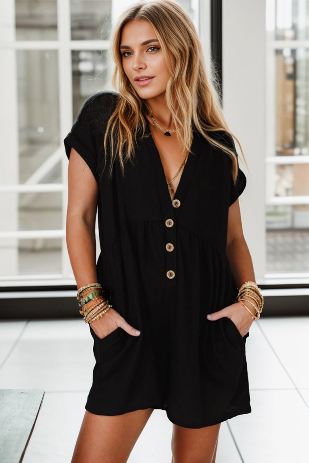 A women wearing a black empire waist romper.