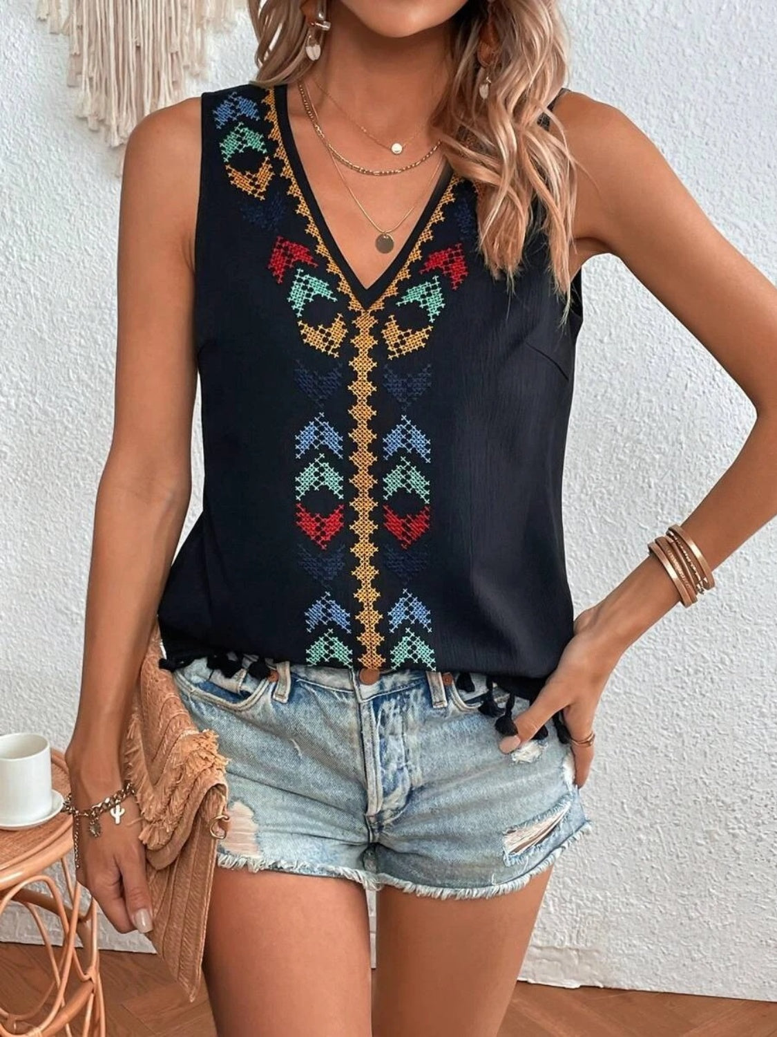 A woman wearing a boho stitch-design tassel hem tank top 