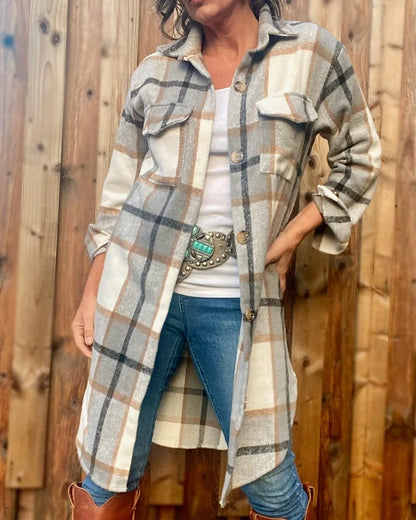 A woman wearing the Renegade Oversized Plaid Flanel shacket in grey, paired with tall leather boots.