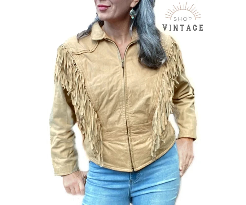 A woman wearing a light tan Western style fringe leather jacket.