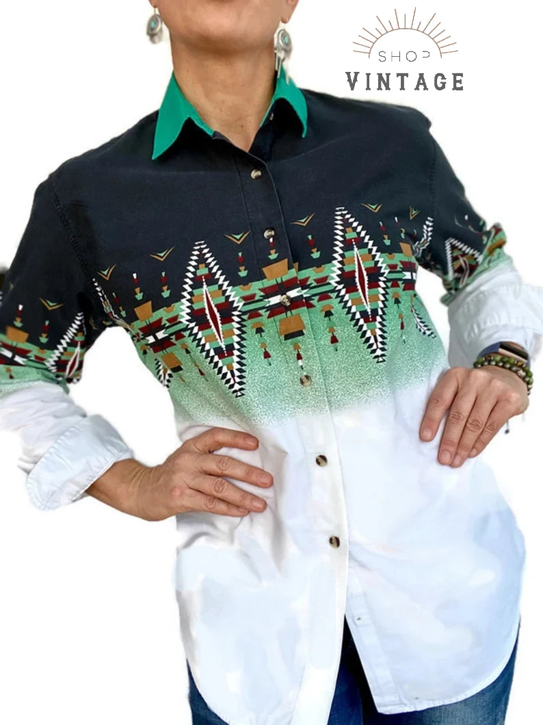 A close up of a woman wearing a green, white and black 90s era Aztec print Western style blouse with a green contrast collar